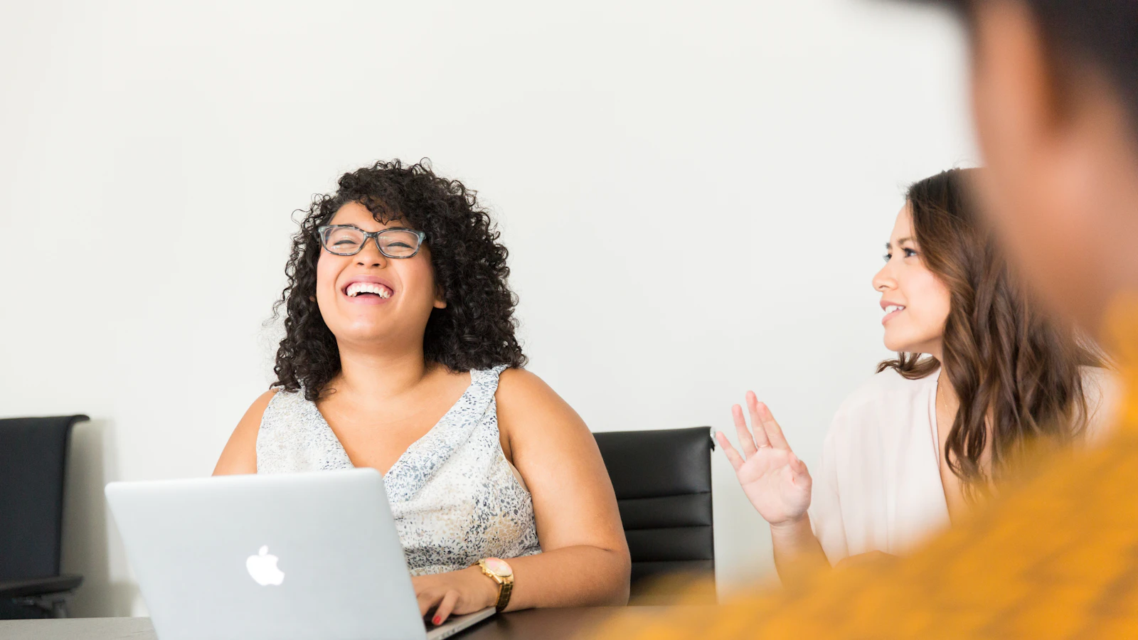 Two founders laughing in a meeting with a laptop
