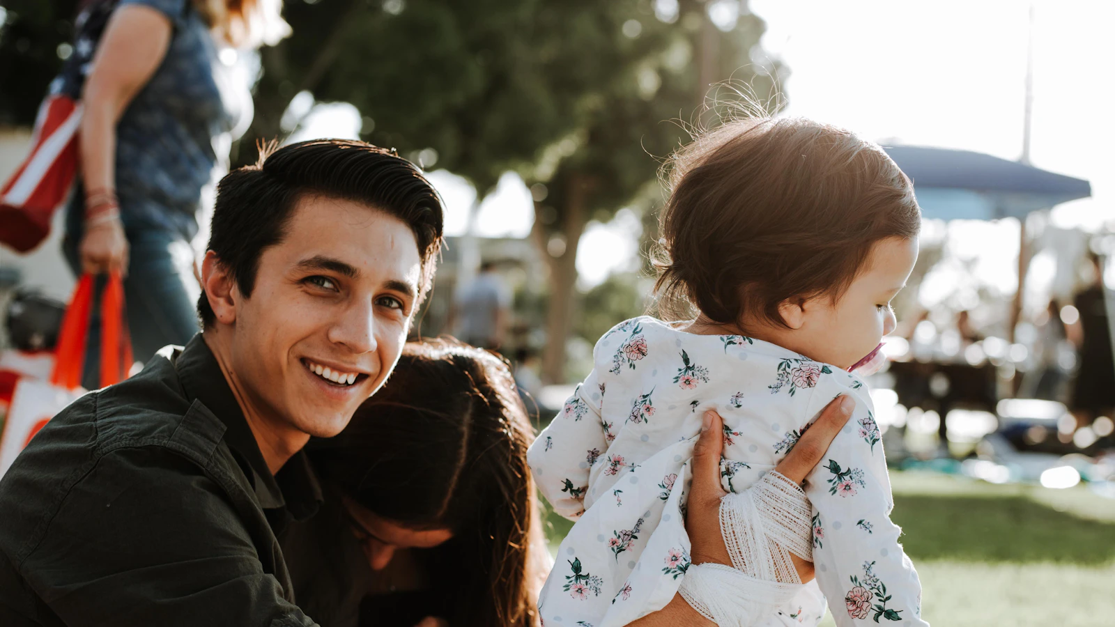 A smiling father with his young child outdoors