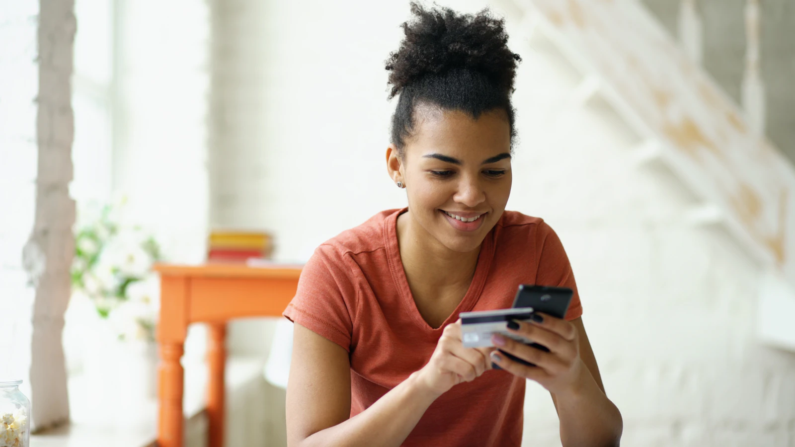 A smiling founder paying with a card on her phone