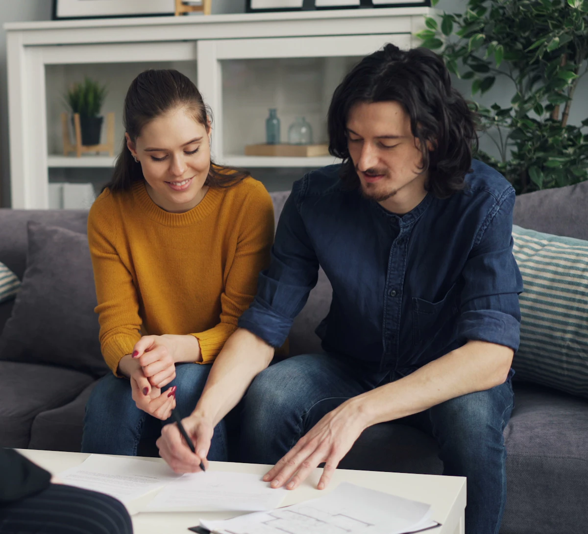 A couple signing documents at home