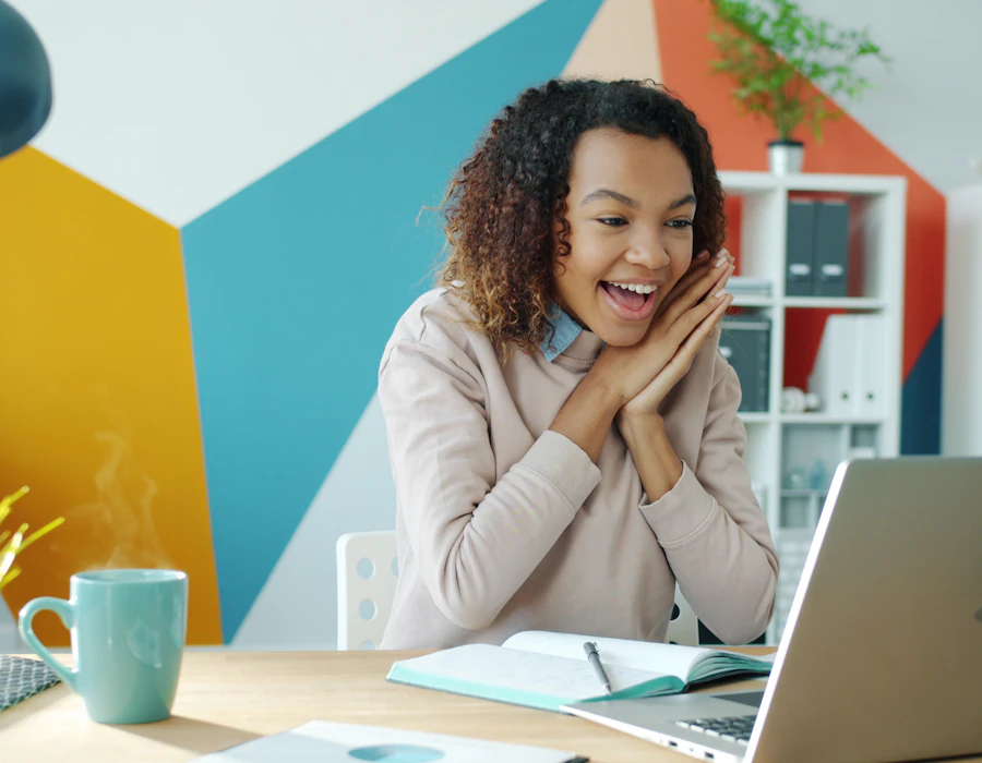 An excited founder looking at her laptop