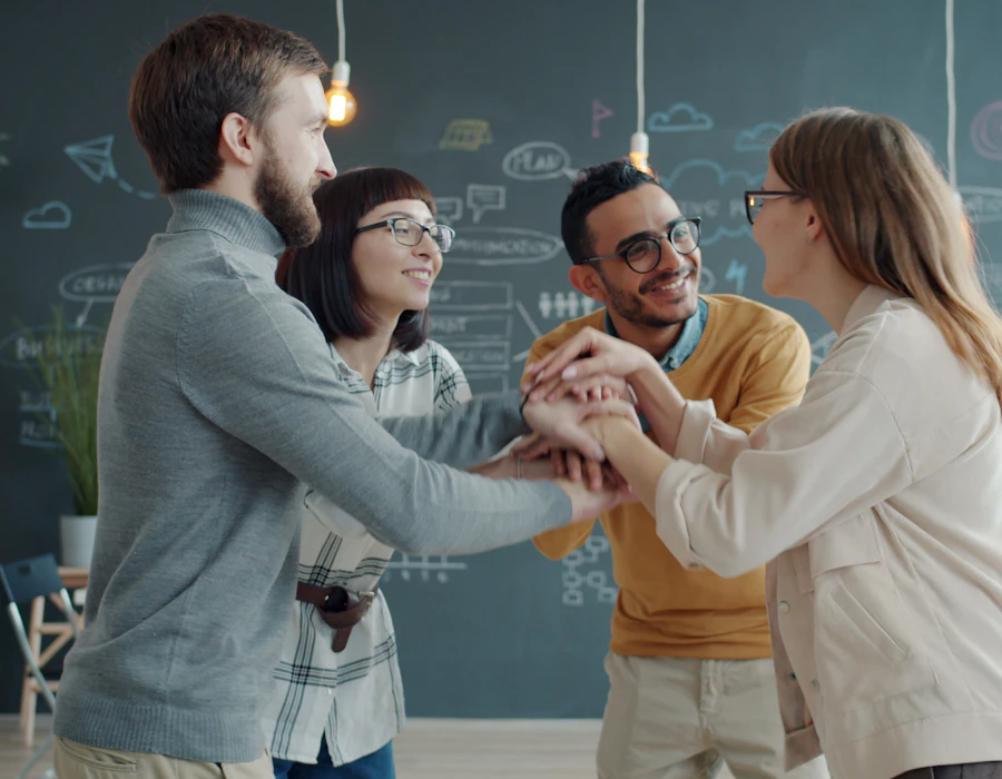 A team stacking hands in a bright office
