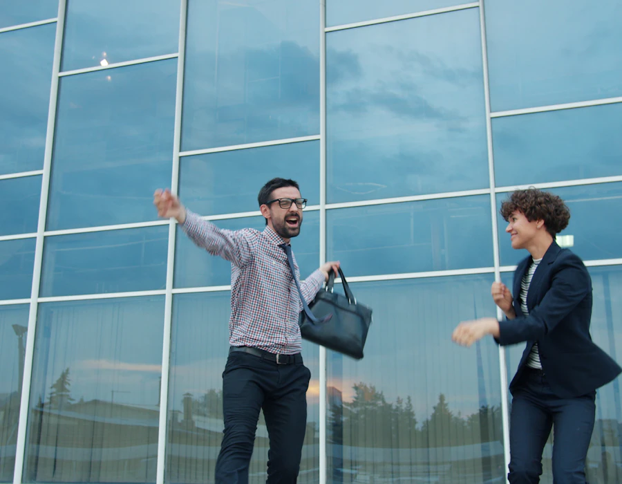 Two founders celebrating outside a glass office building