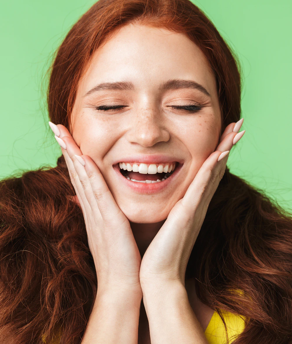 A founder laughing with her hands on her cheeks