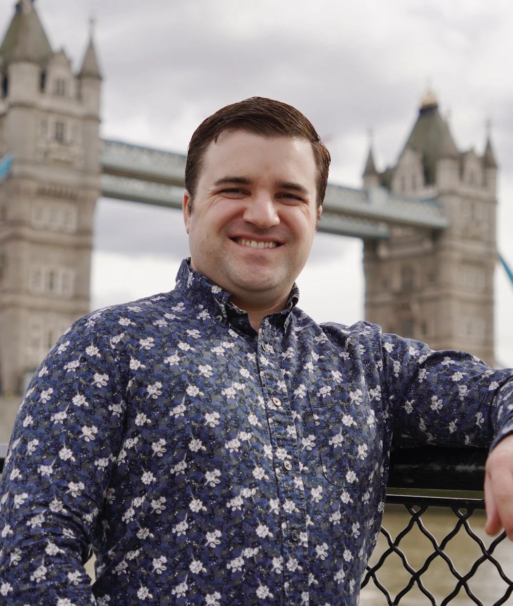 A smiling founder in front of Tower Bridge in London